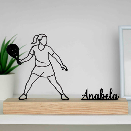 Estátua desportiva de mulher a praticar padel, com base em madeira natural.